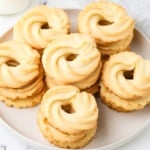 Danish butter cookies with crisp ridges arranged on a white plate.