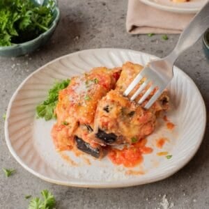 A close up image of eggplant parmesan on a plate.