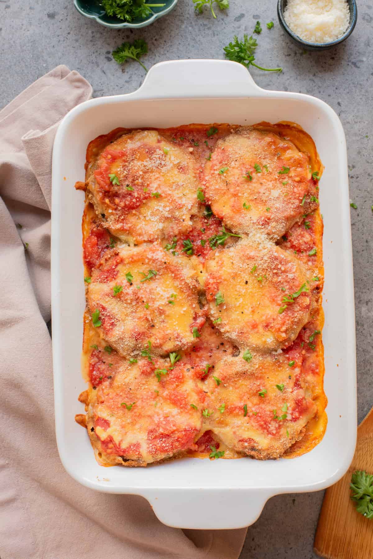 An overhead image of baked eggplant parmesan in a baking dish.