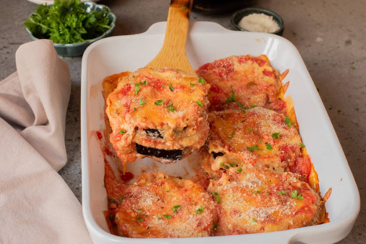 Un gros plan du parmesan d'aubergine dans un plat de cuisson.