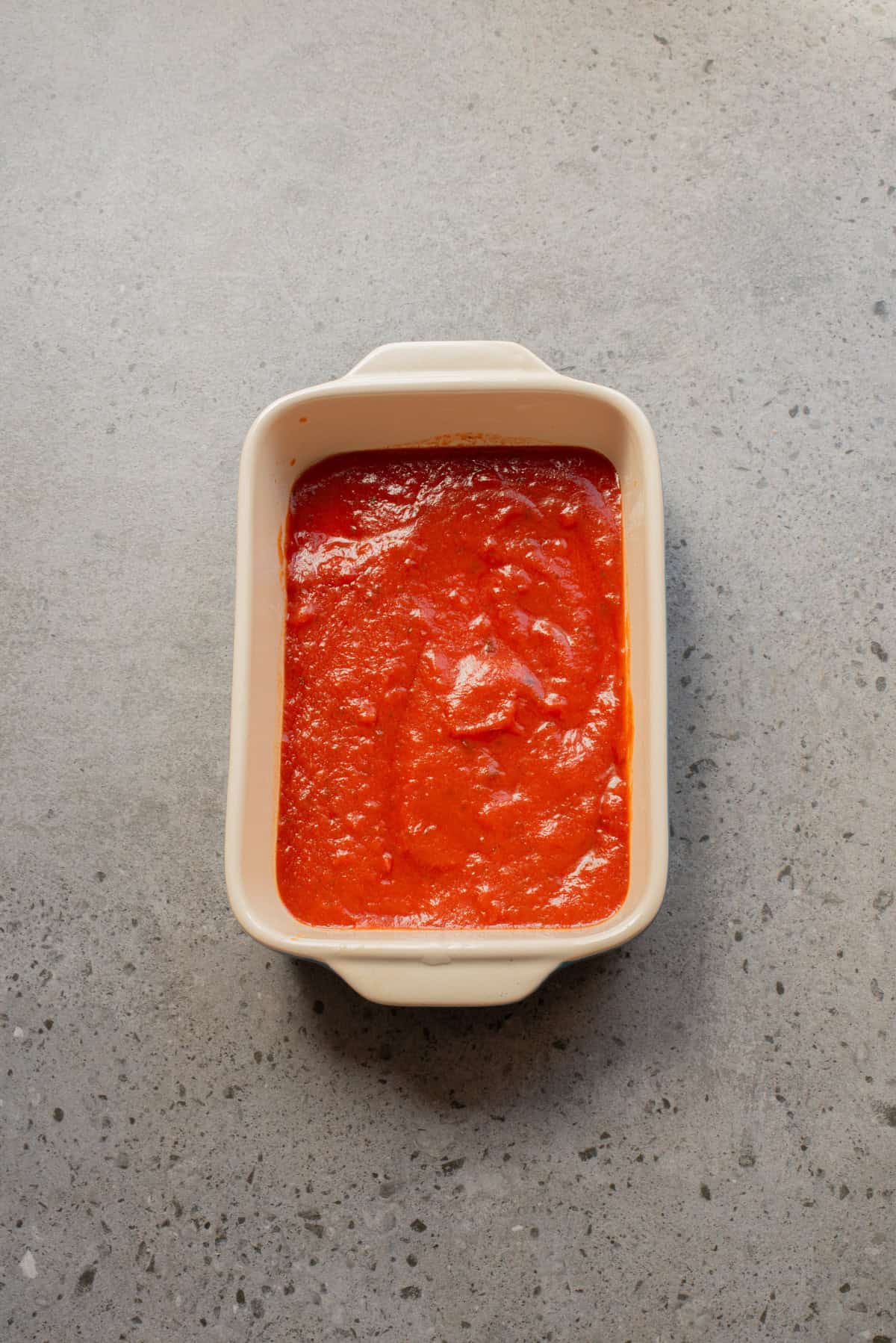 An overhead image of marinara sauce on a baking dish.