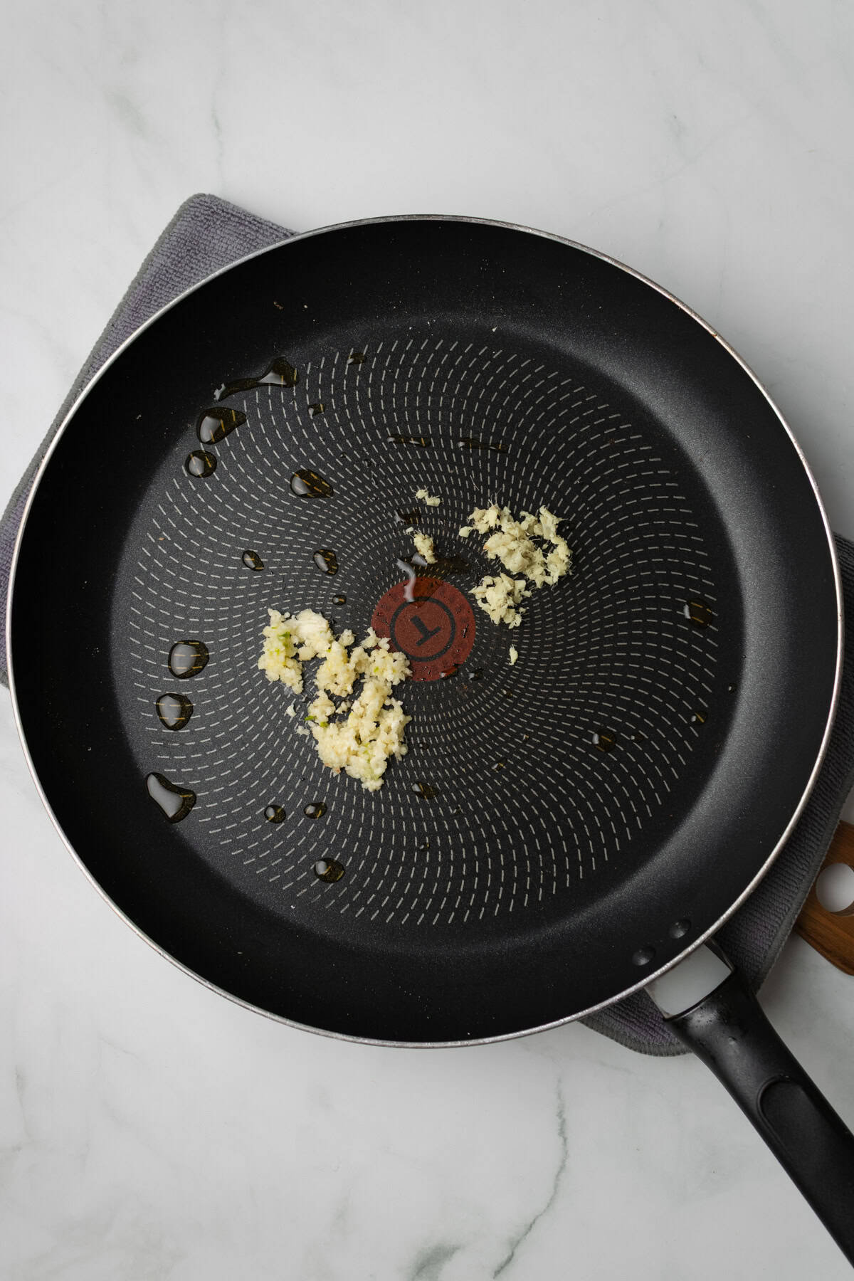An overhead image of garlic and ginger on a skillet.