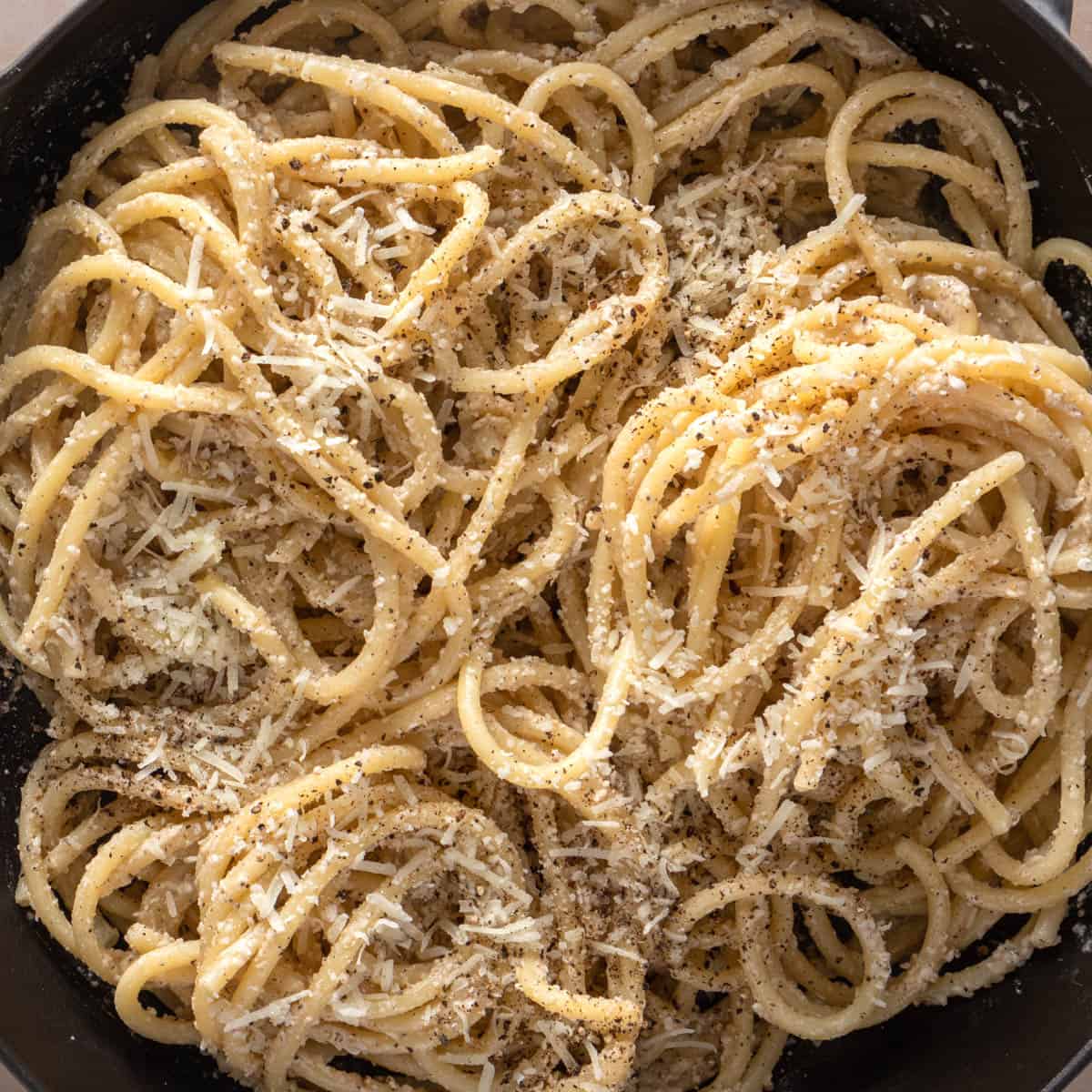 Close up of bowl of cacio e pepe showing the cheese and pepper garnished pasta