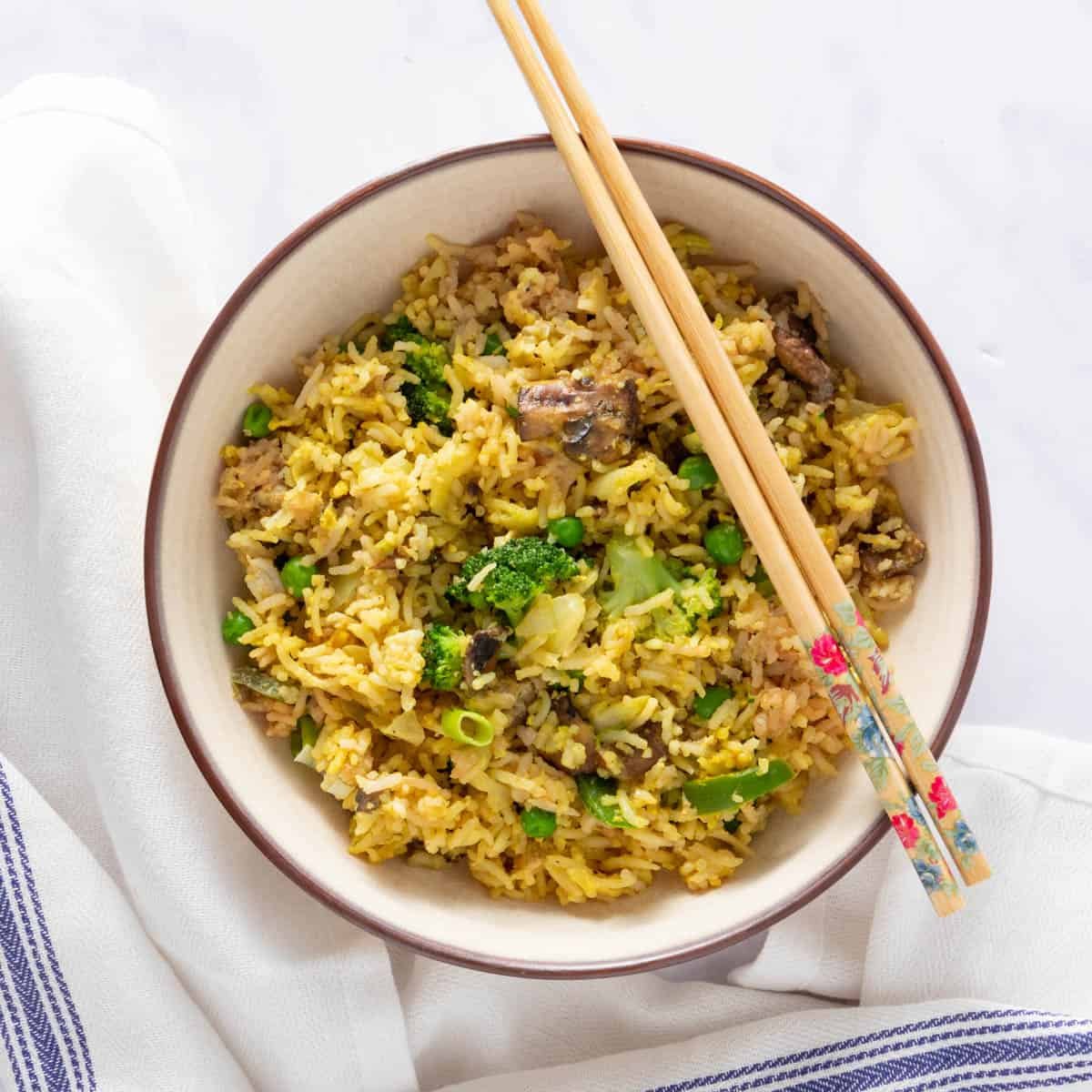 Bowl of vegetarian fried rice, with napkin and chopsticks on the side