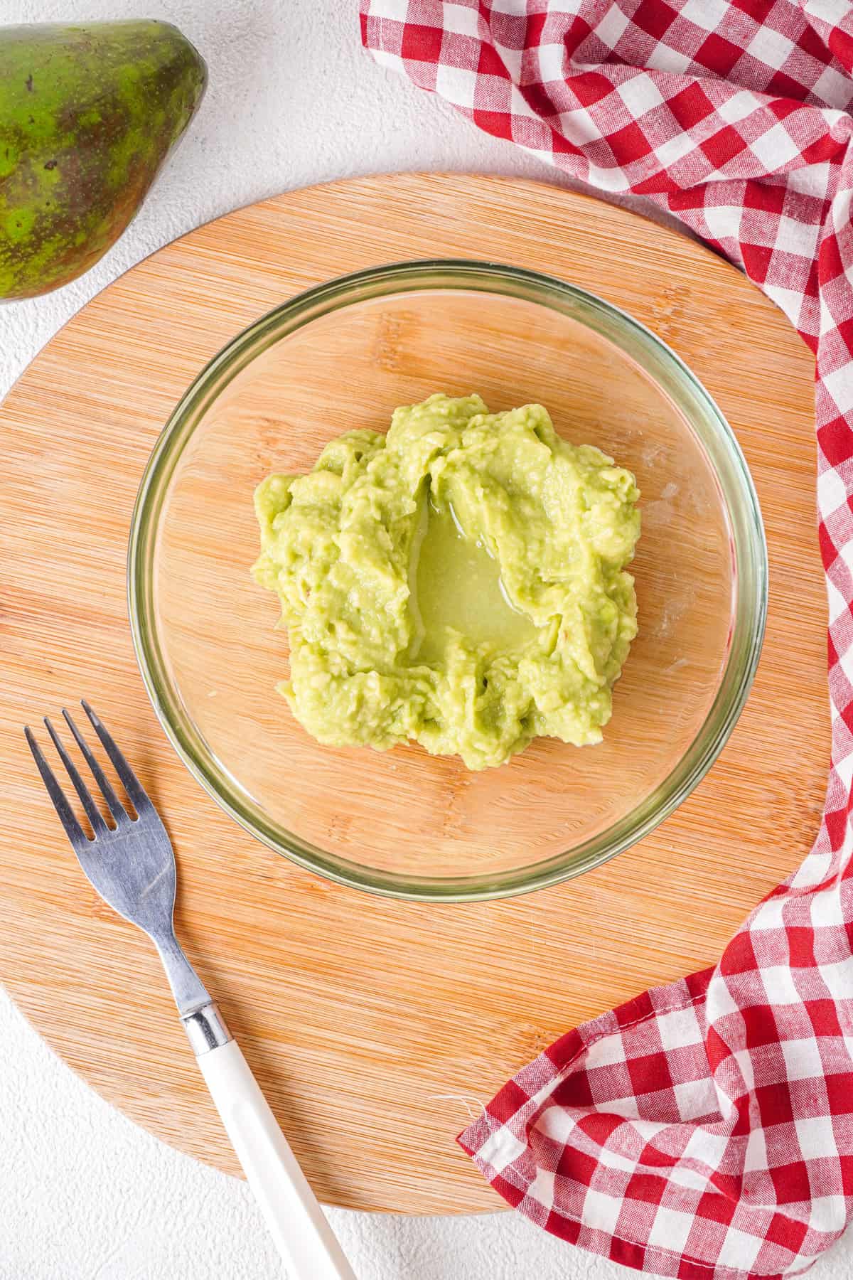 Overhead view of mashed avocados with lemon juice added
