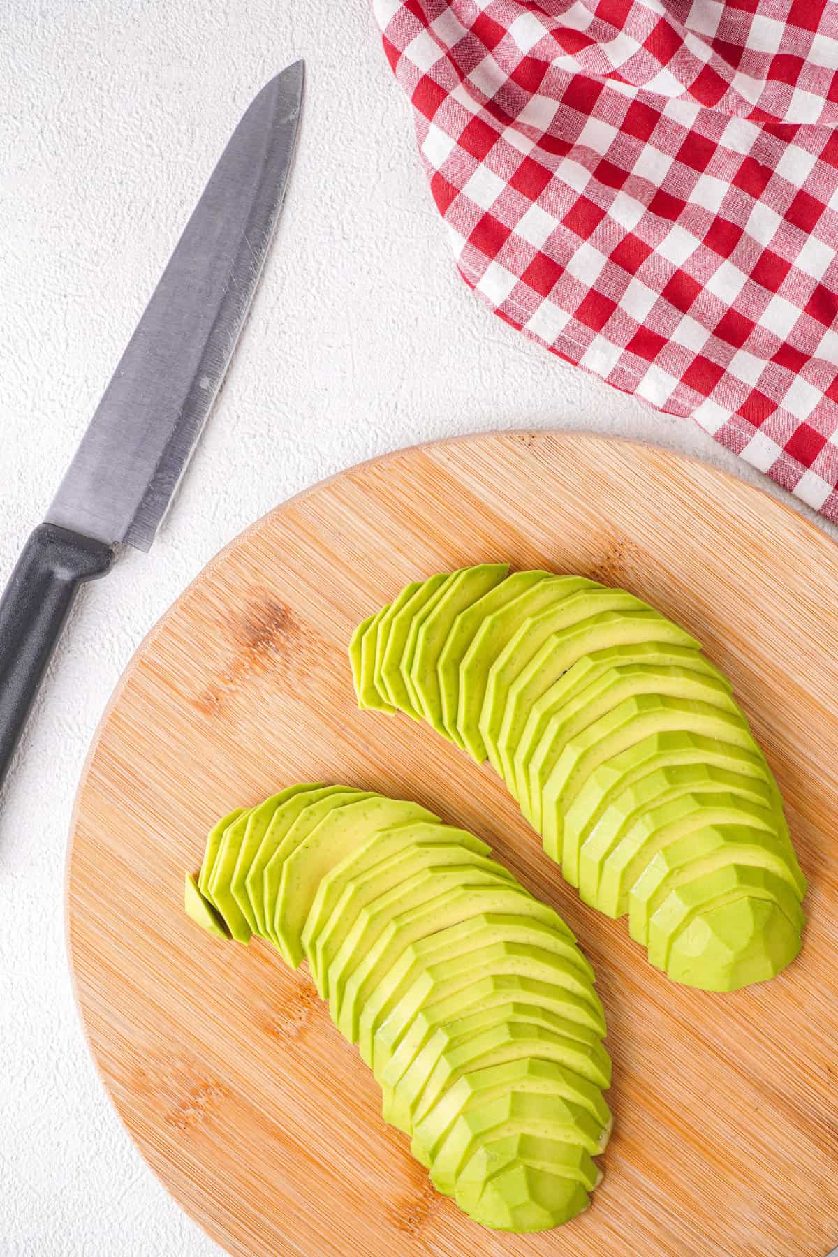 Overhead view of avocado slices on a wooden board