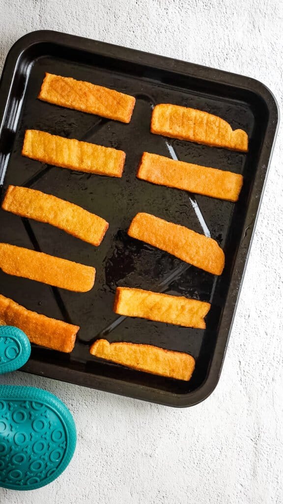 French toast sticks on black tray after air frying