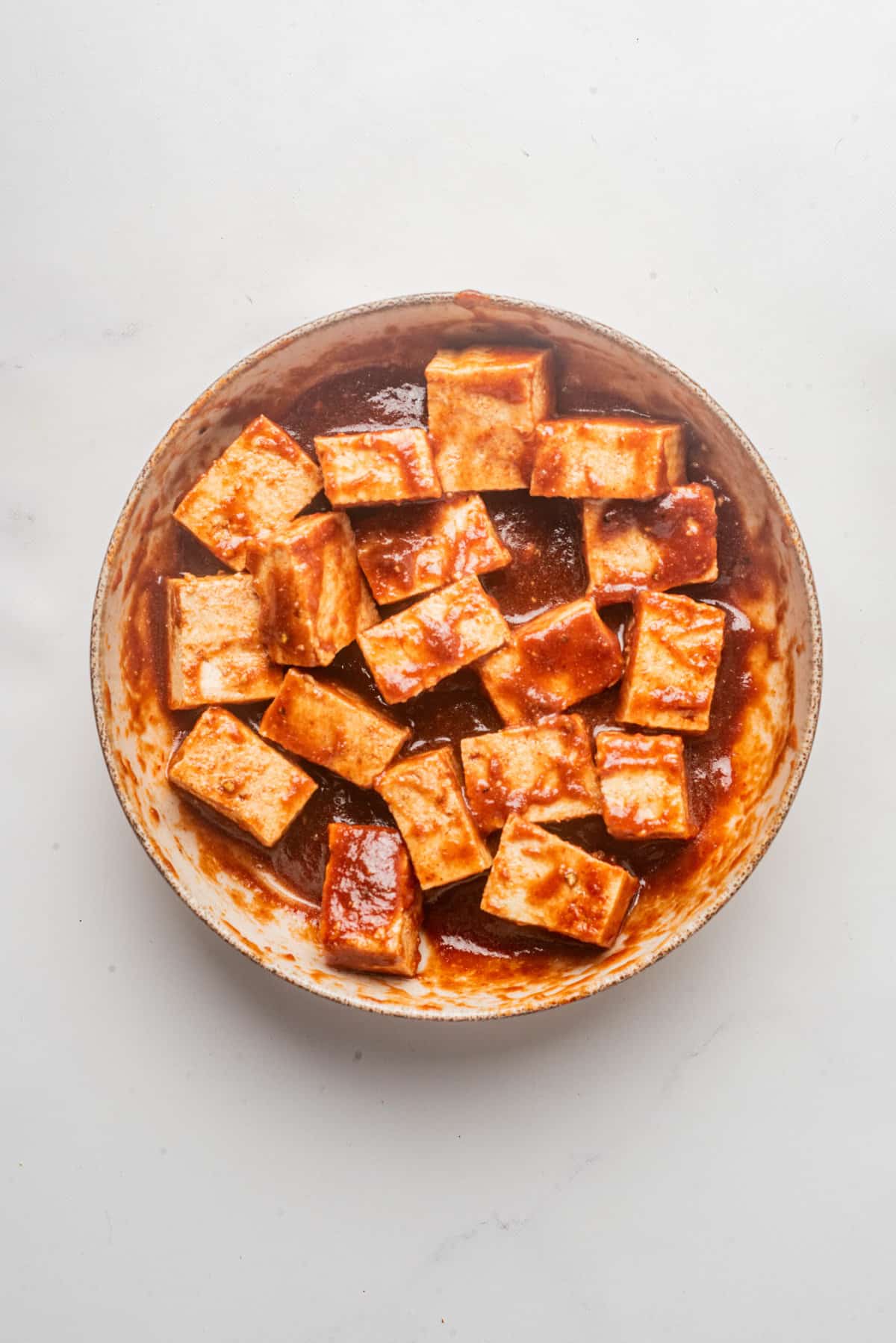 An image of tofu tossed in a gochujang sauce mixture.