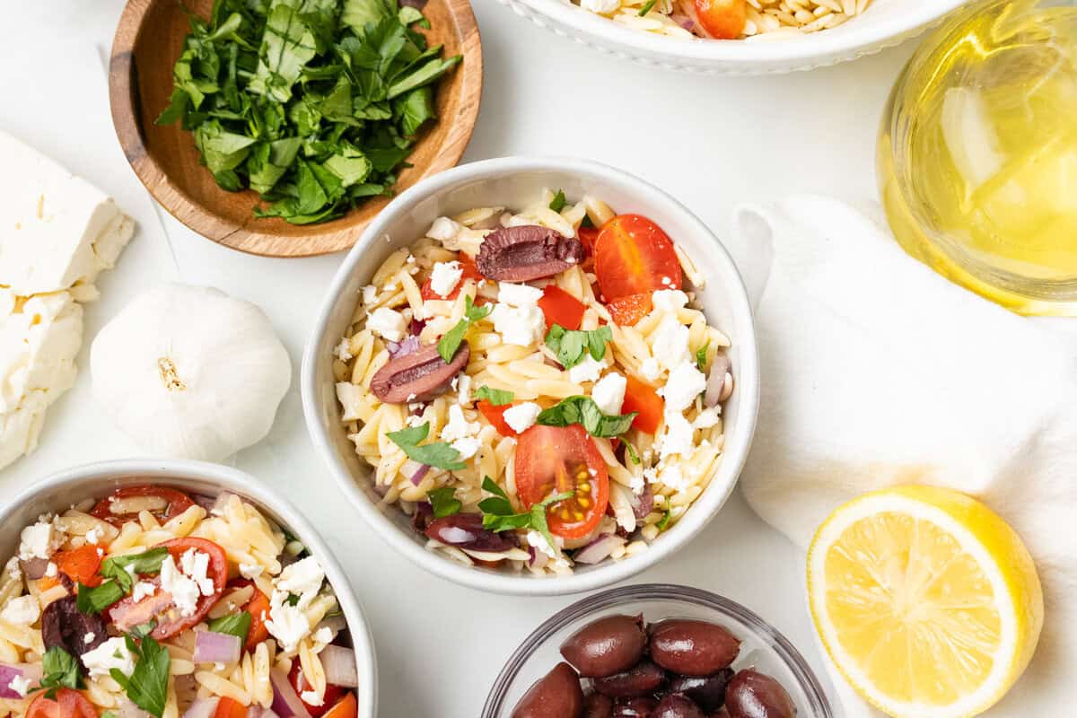 An overhead image of Greek orzo salad served in small bowls.