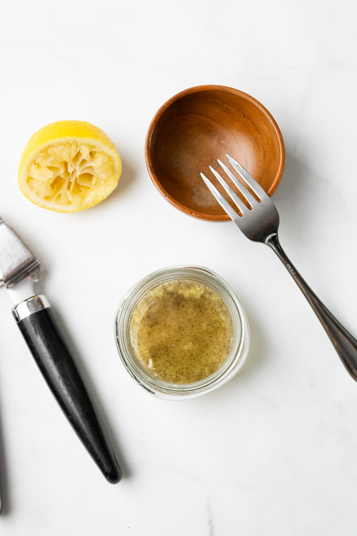 An overhead image of whisking the dressing together in a jar.
