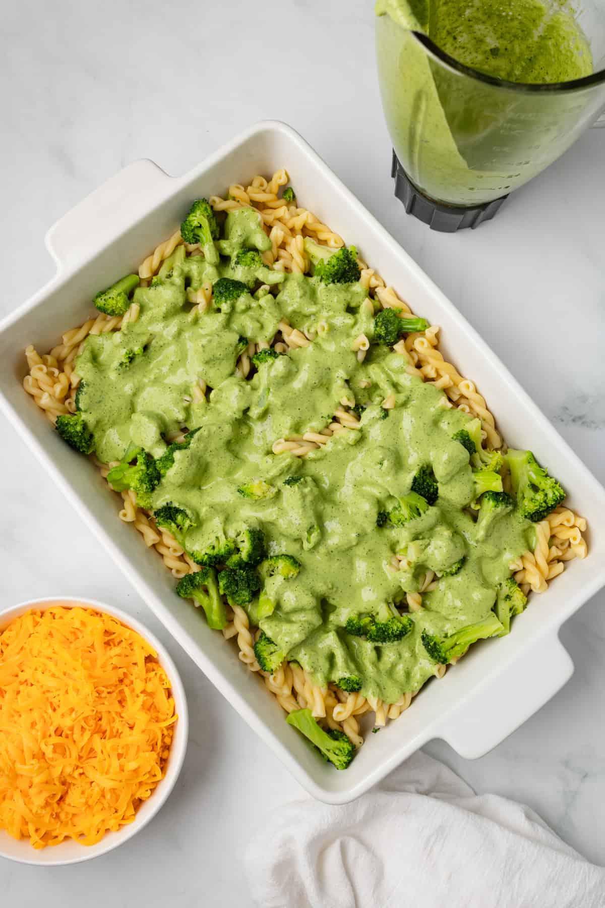An overhead image of arranging the pasta bake in a casserole dish.