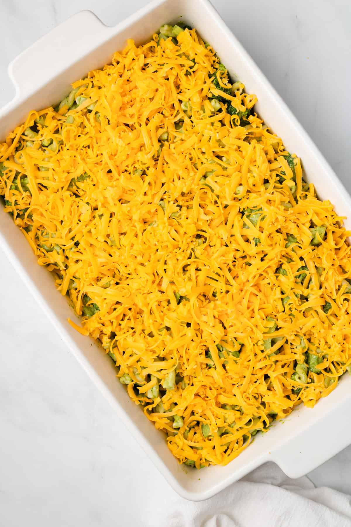 An overhead image of prepared green goddess bake on a baking dish, ready to be baked in the oven.