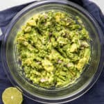 Close up of bowl of guacamole on a blue napkin