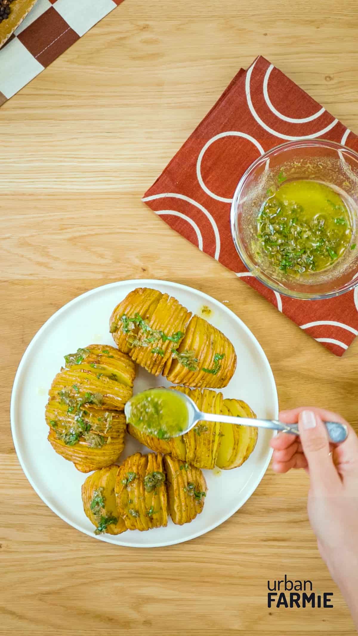 An overhead image of oil being drizzled on hasselback potatoes.