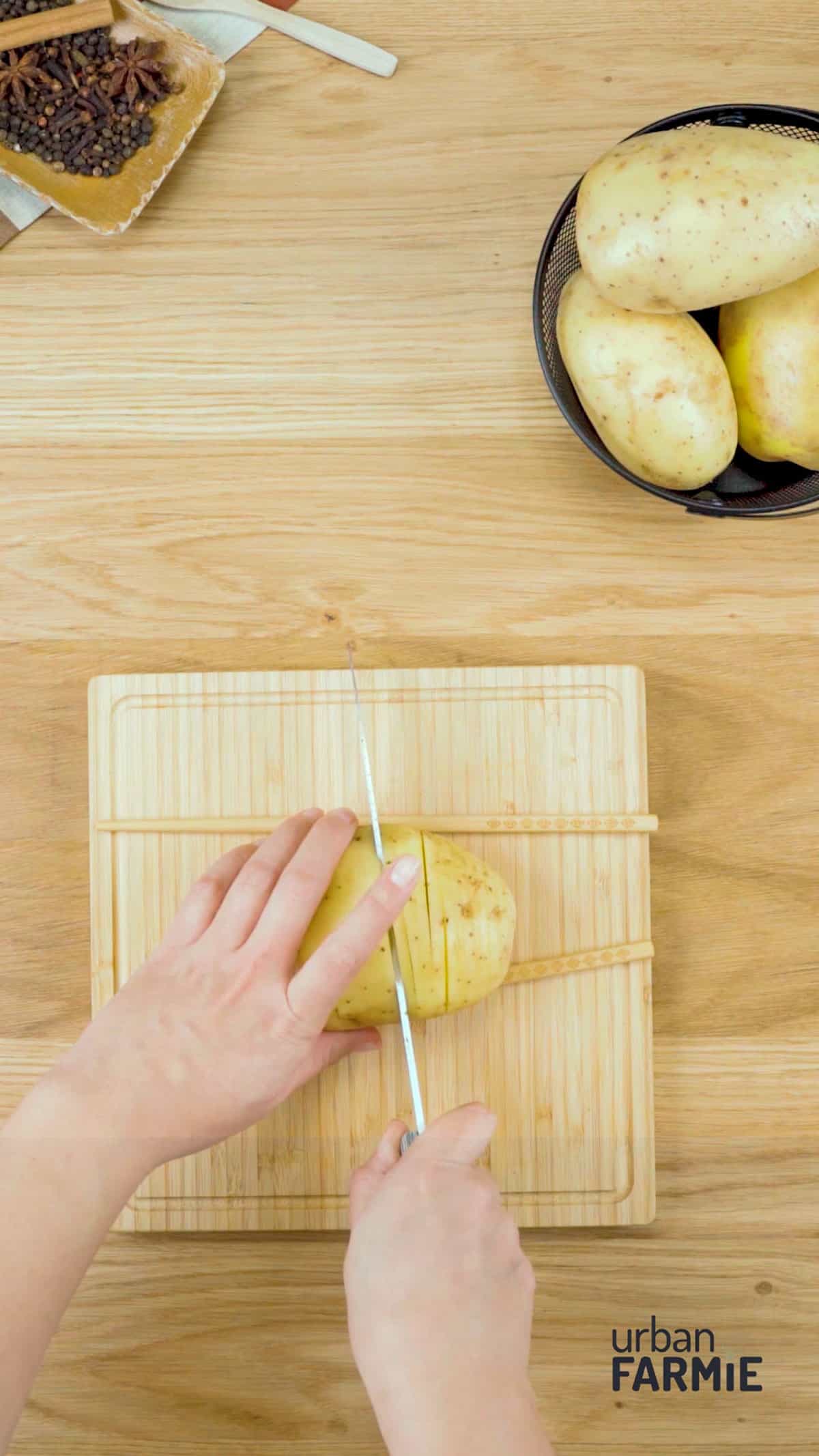 An image of a potato being slit on a chopping board.