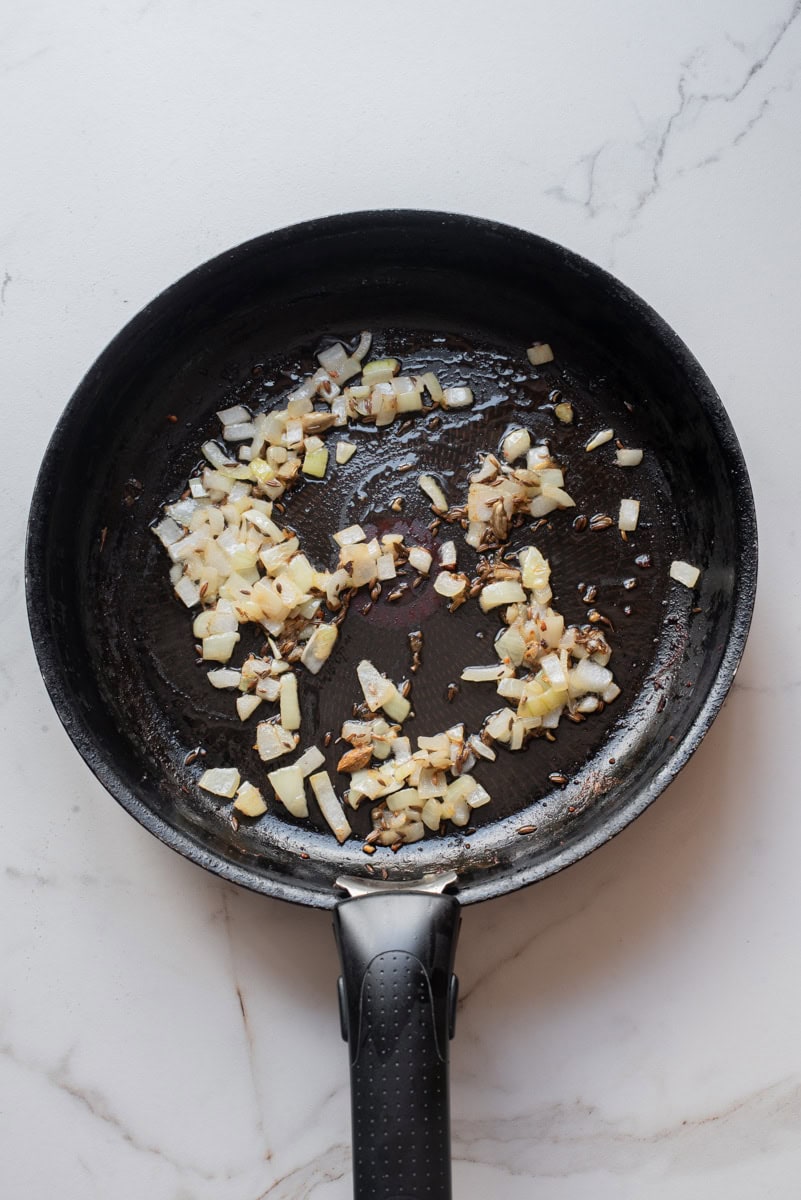 An overhead image of sauteing onions, garlic, and ginger.