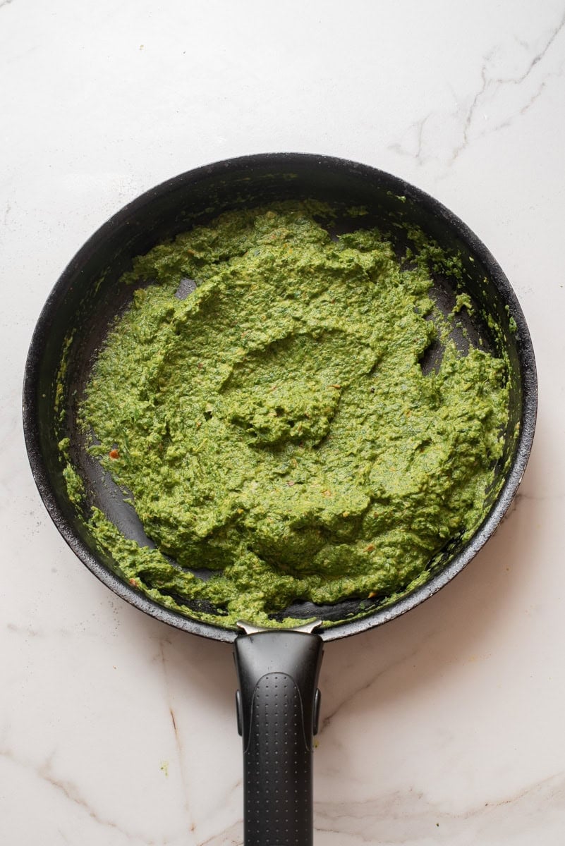 An overhead image of blending the spinach mixture until smooth and creamy.