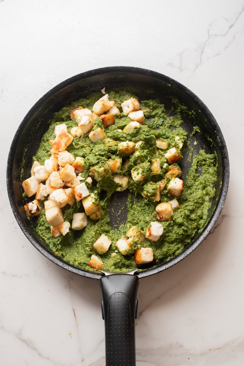 An overhead image of adding back the paneer.