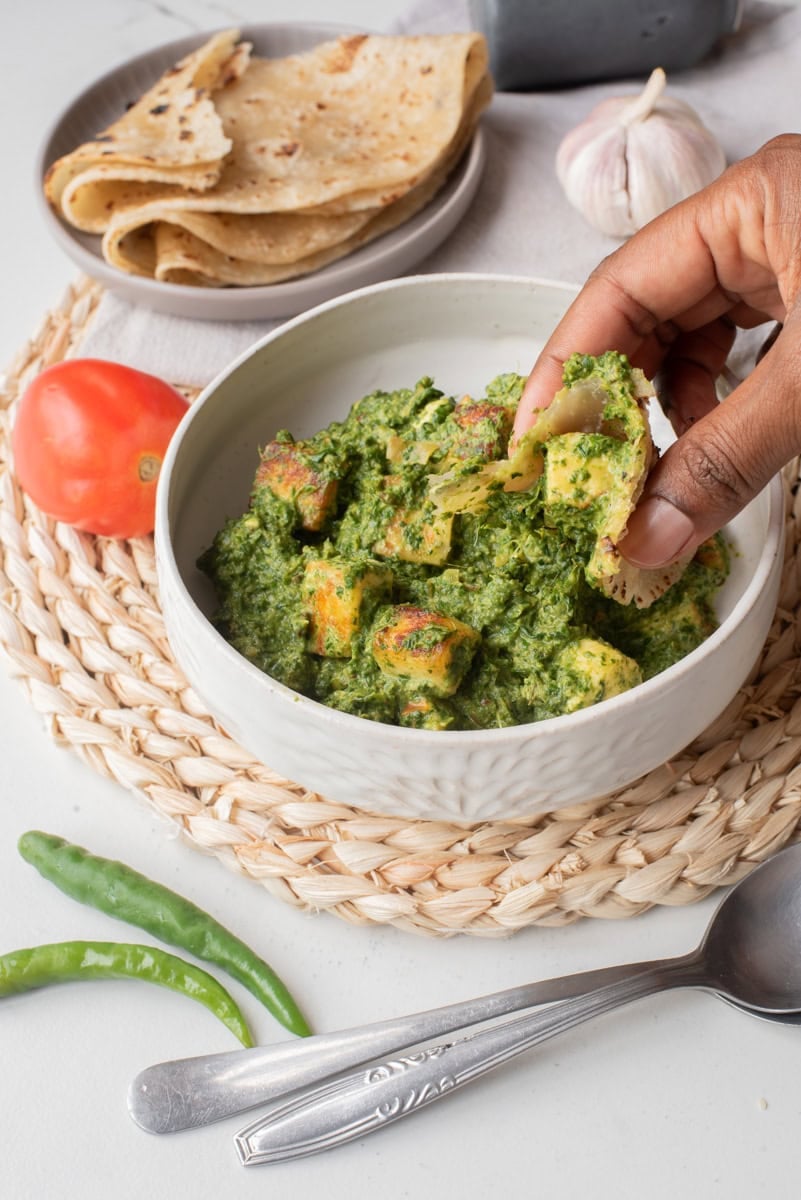 A close up image of the palak paneer served in a bowl.