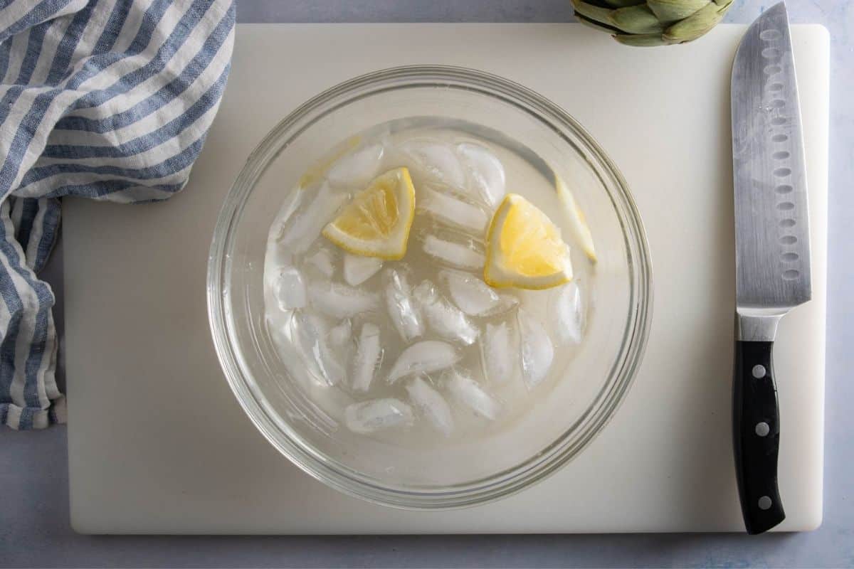 Prepare a bowl of ice water with lemon juice and wedges to store artichokes and prevent browning