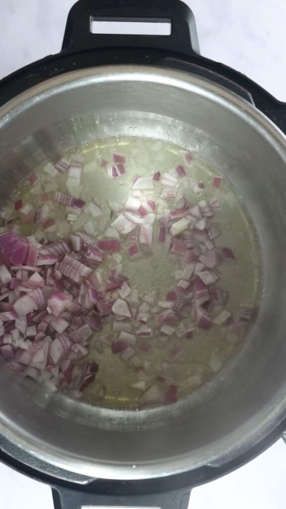 Sautéing onions in the inner pot of the Instant Pot. 