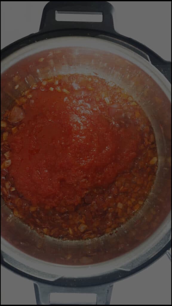 Adding blended tomato-pepper puree to inner pot of Instant Pot.