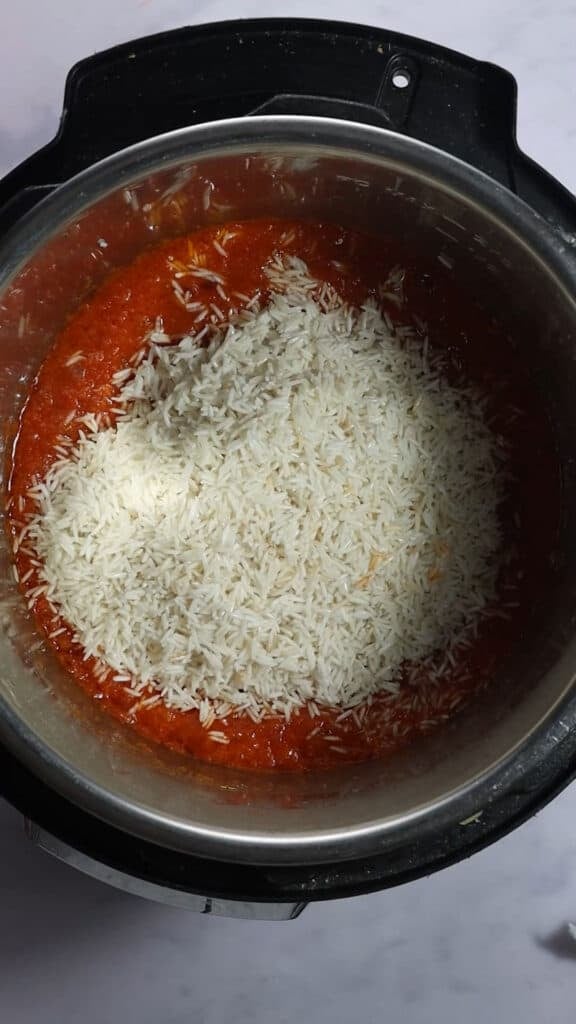 Adding rice to puree in inner pot of Instant Pot.