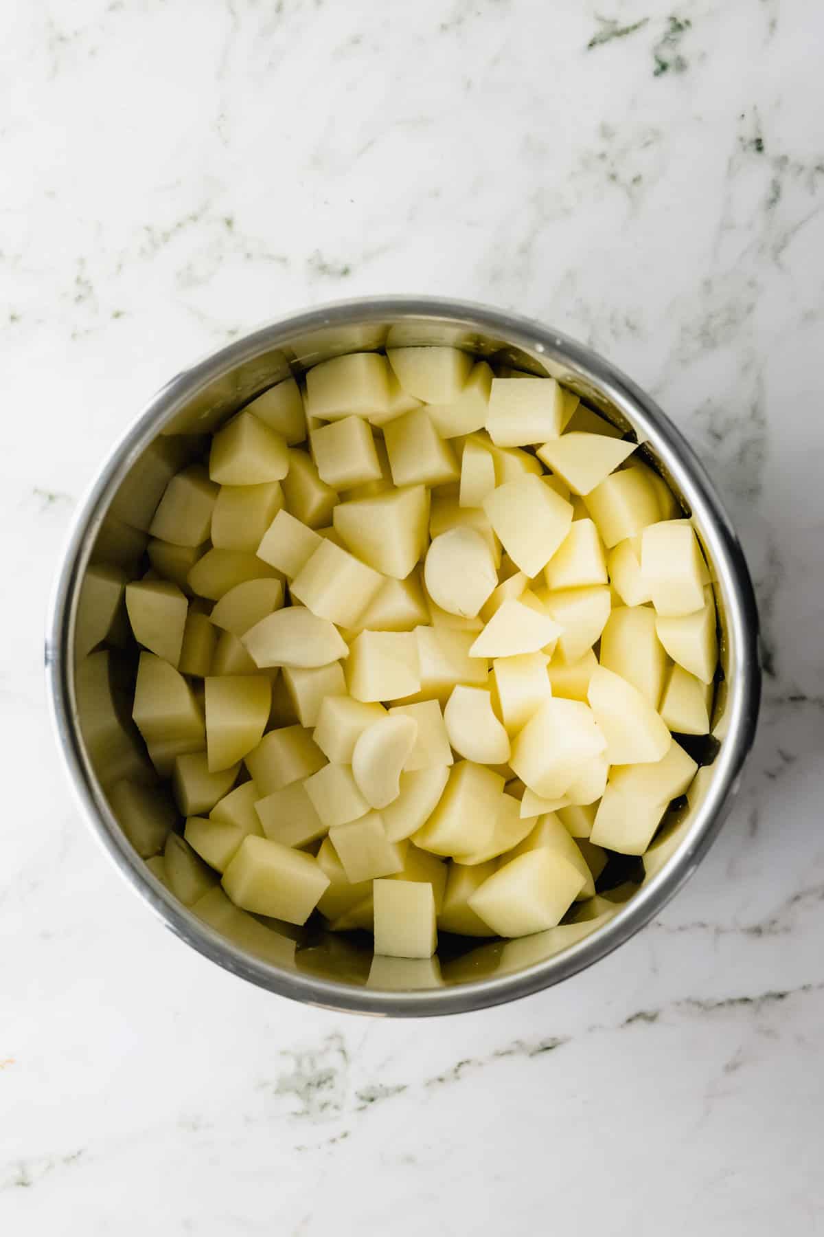 Overhead view of pot with cubed potatoes.