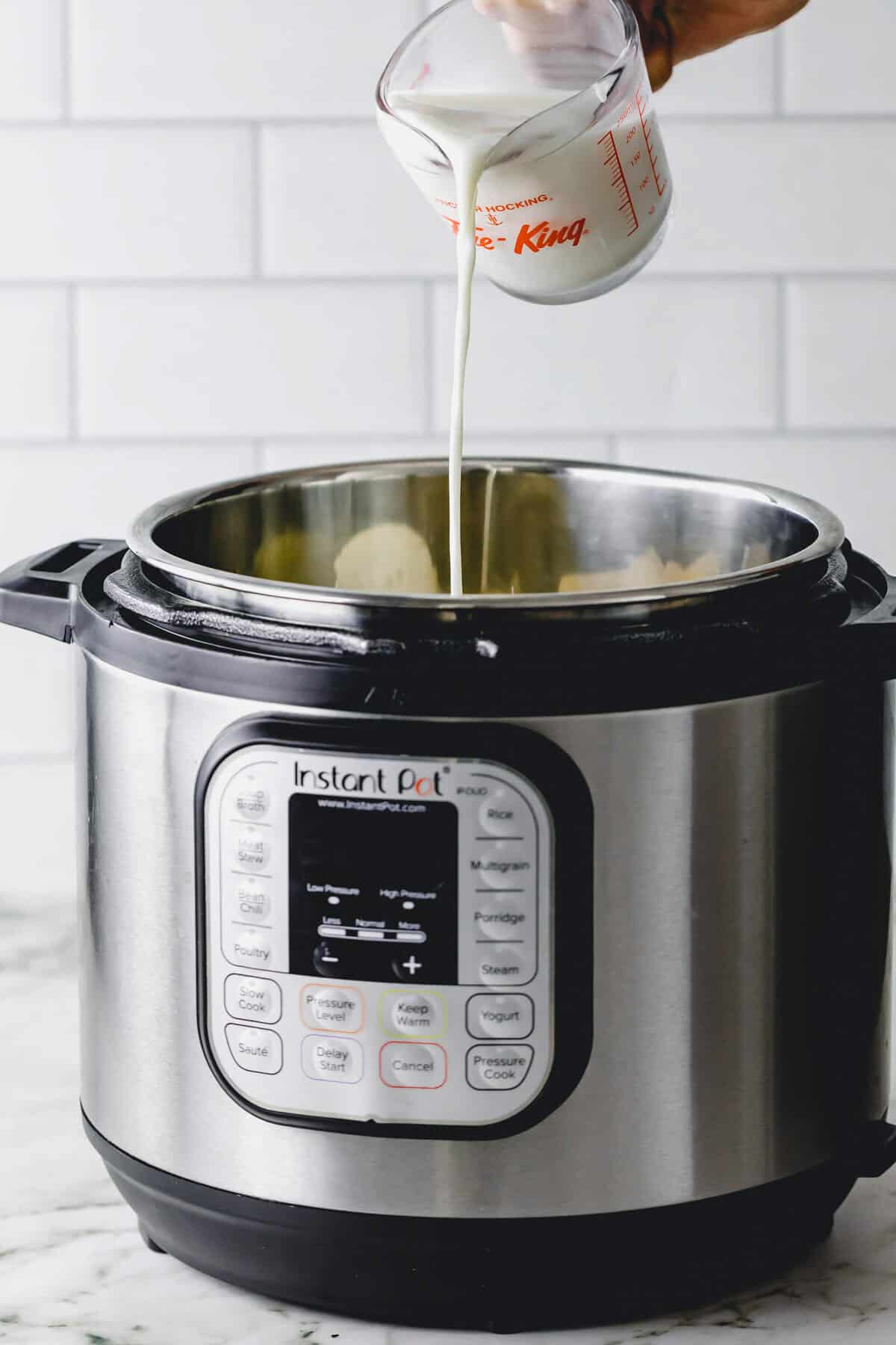 Side angle showing milk being added to Instant Pot.