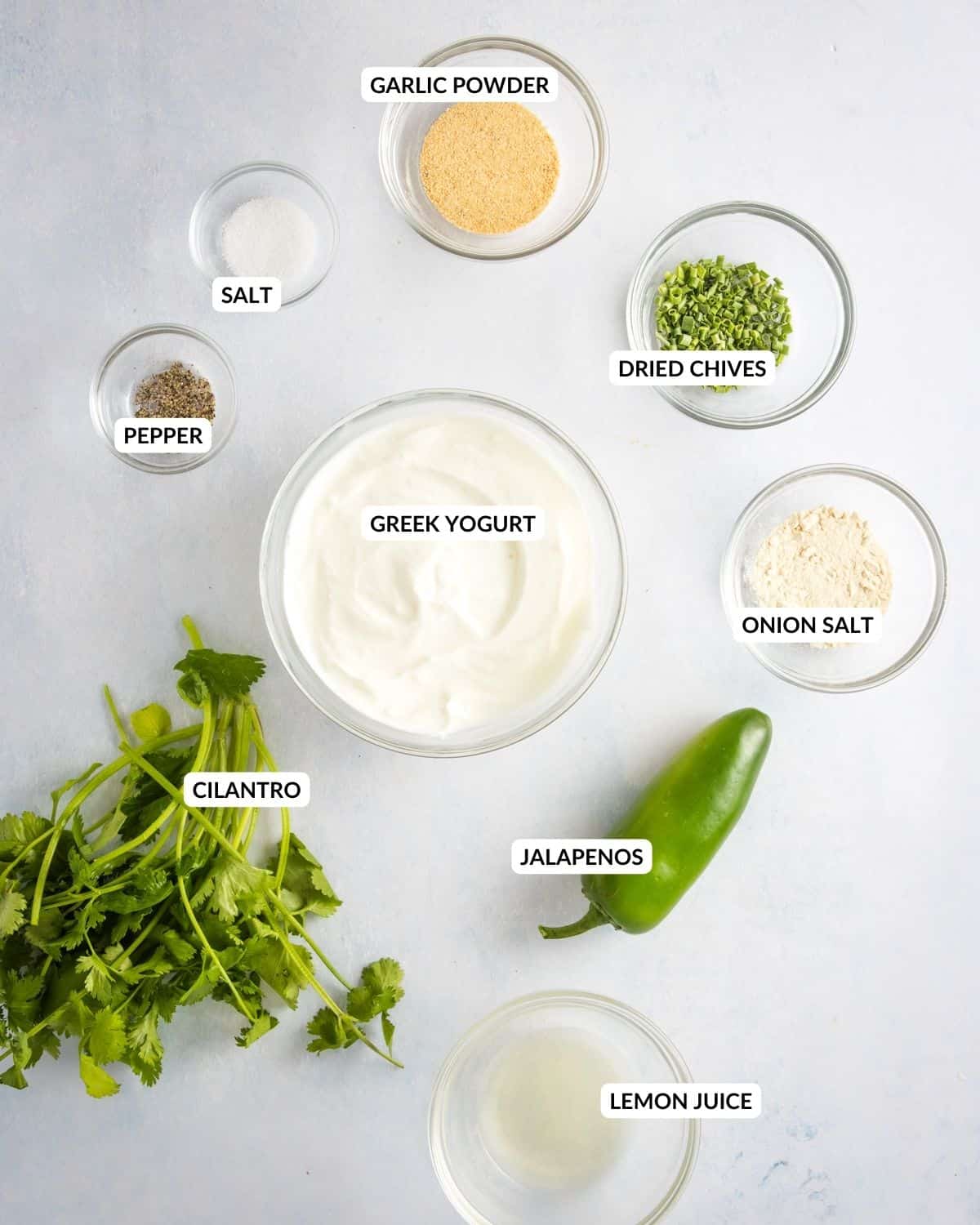 An overhead image of the ingredients of jalapeno ranch dressing laid out on a table.