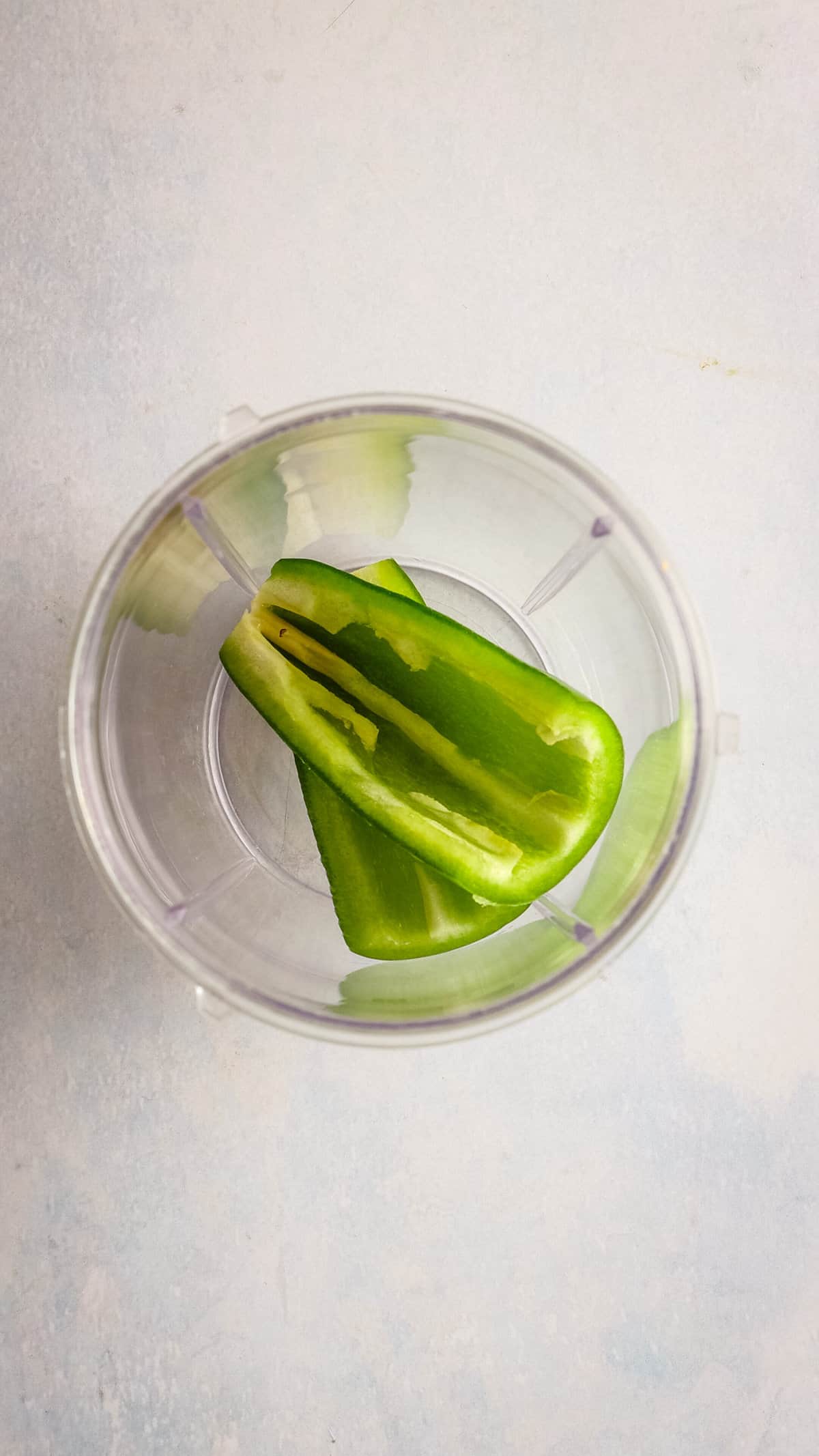 An overhead image of sliced jalapeno in a blender.