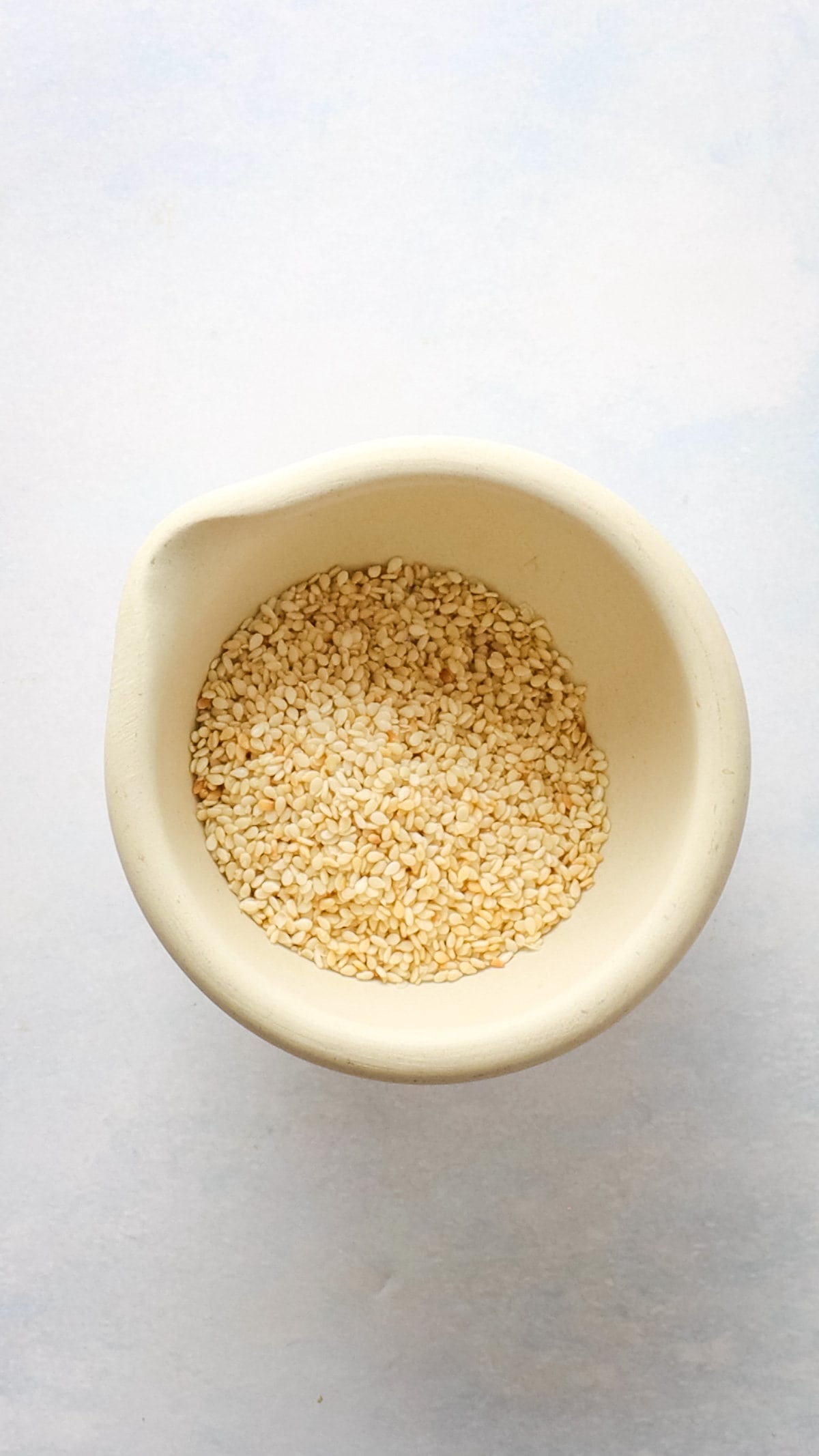An image of toasted sesame seeds in a mortar and pestle.