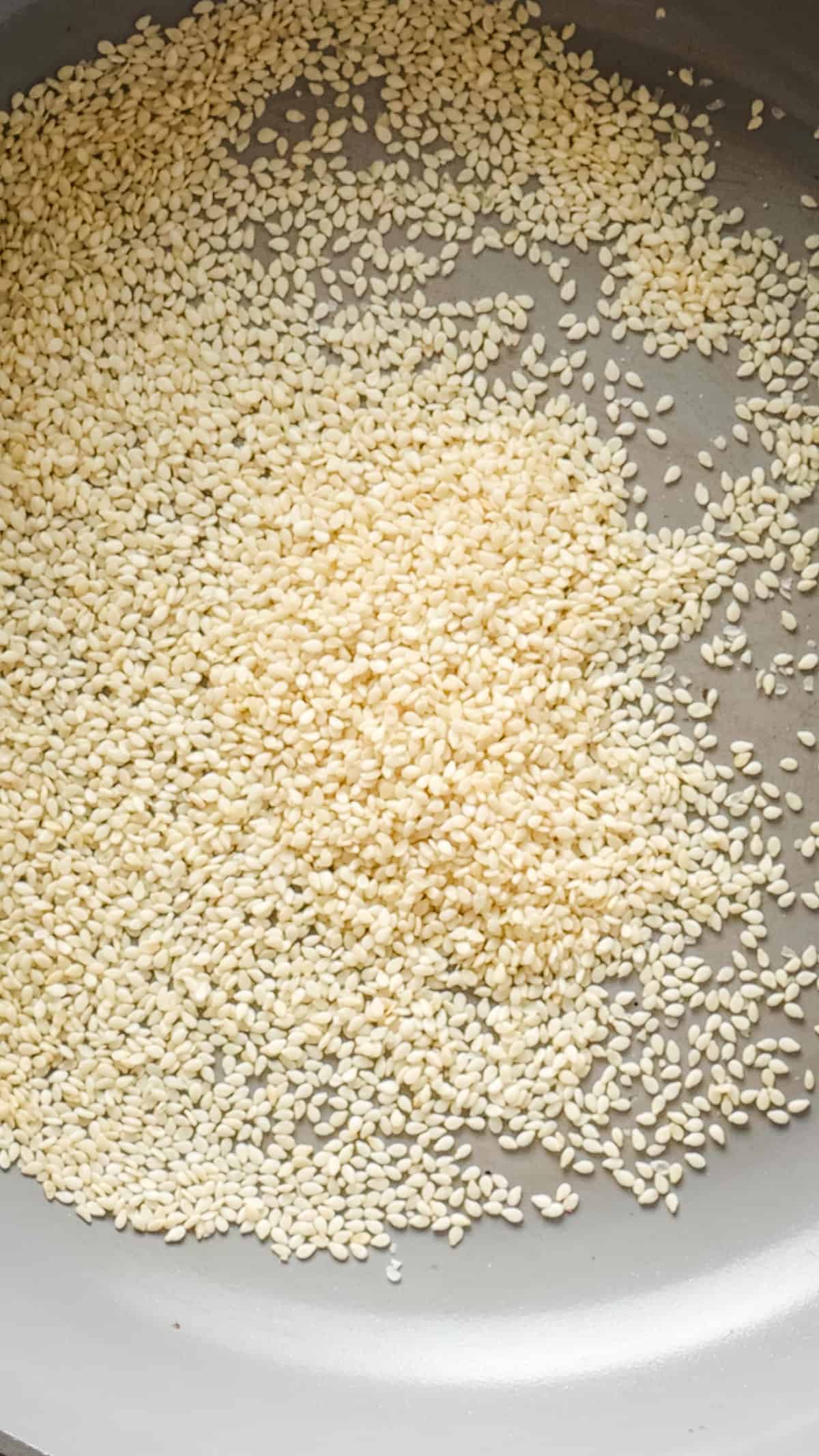 An image of sesame seeds in a large bowl before being toasted.