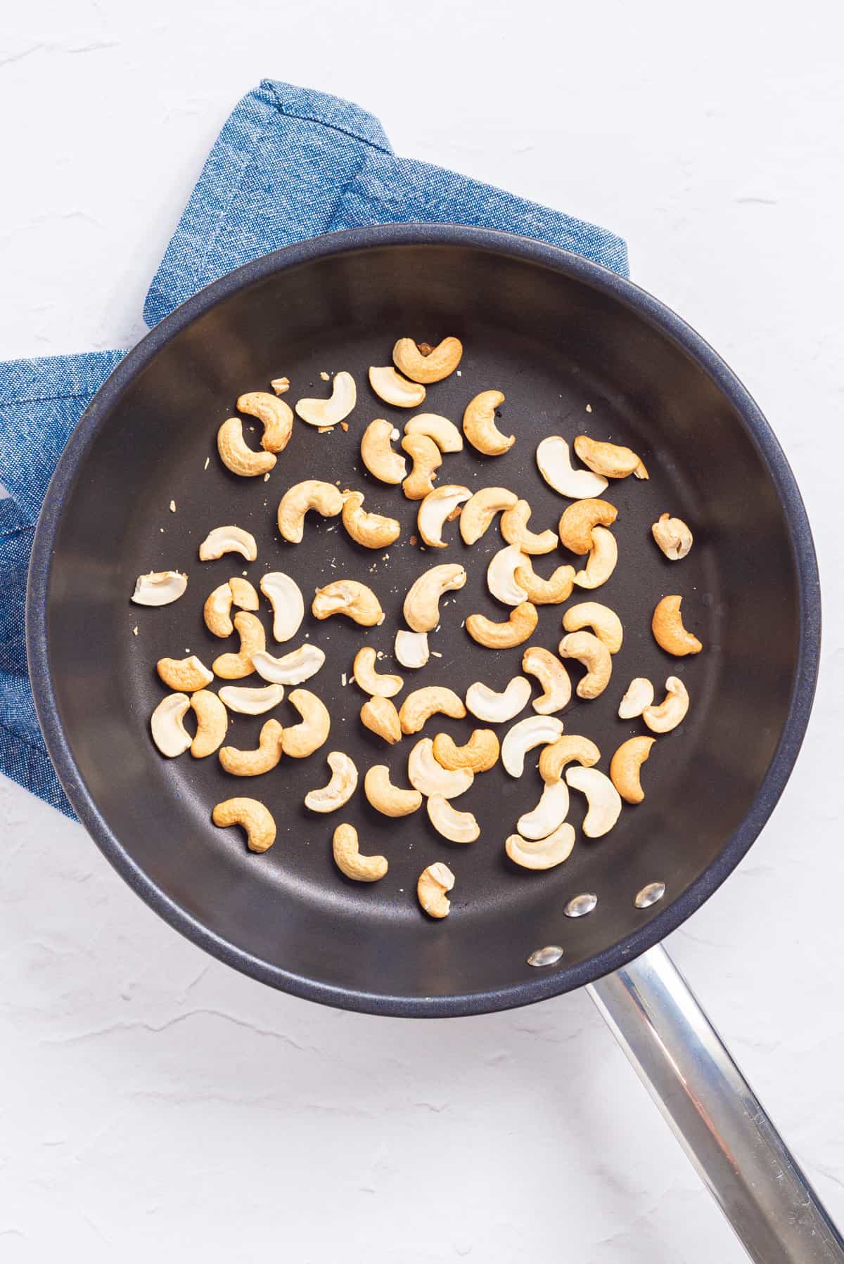 An image of sliced and toasted cashews in a pan