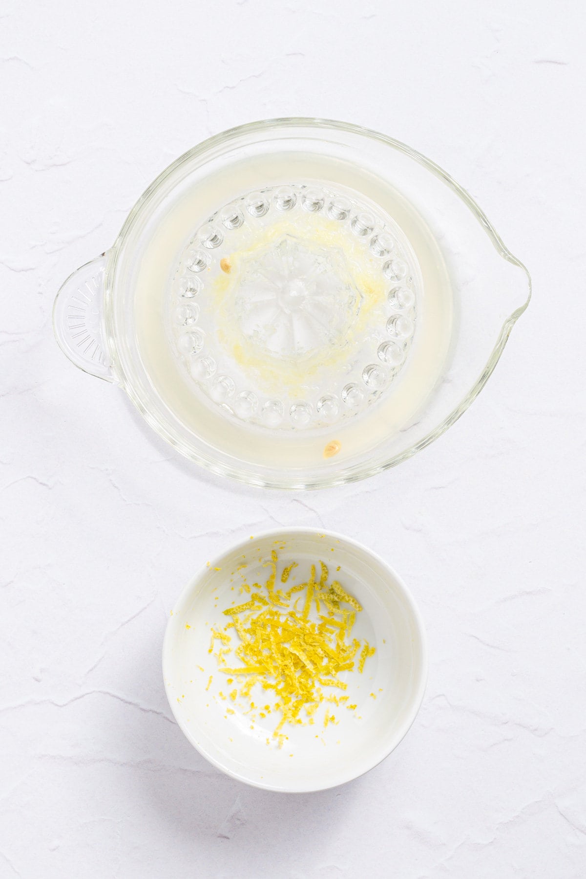 An overhead image of lemon juice and lemon zest in separate containers