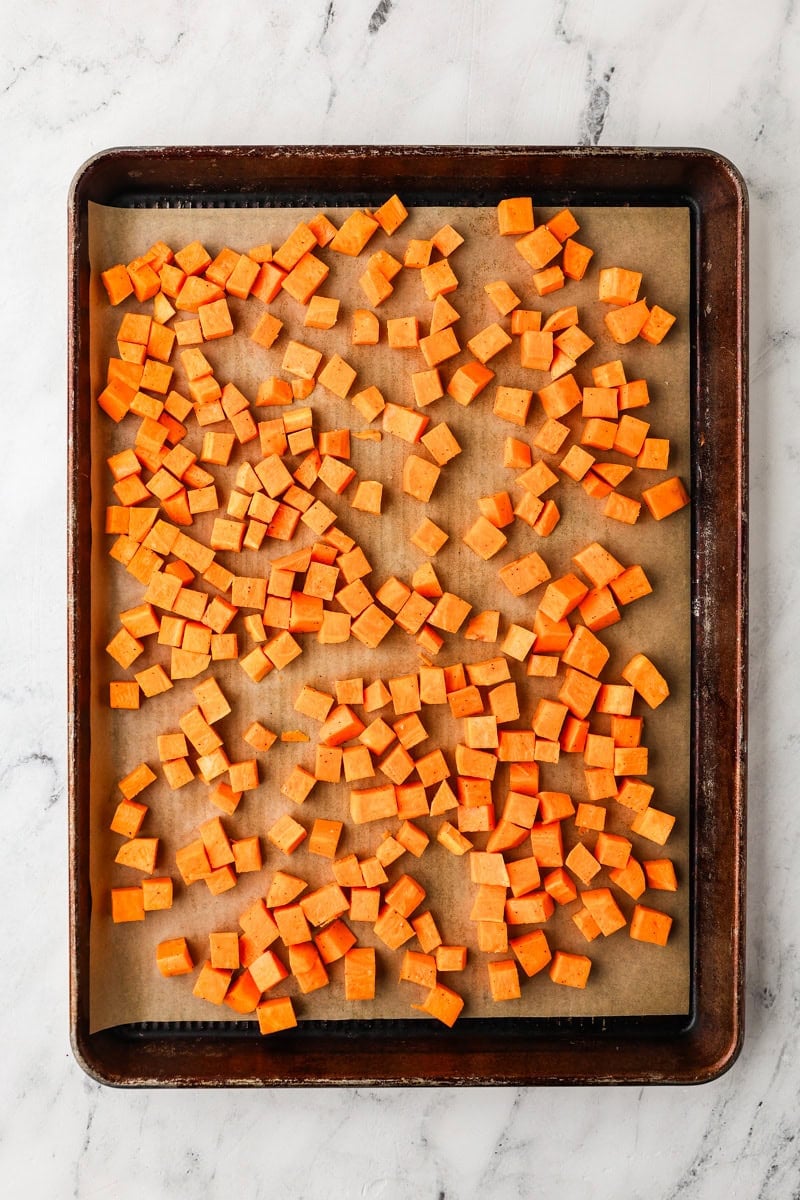 An overhead image of roasting the sweet potato cubes on a baking sheet.