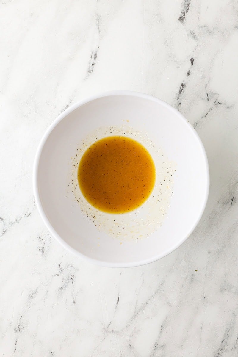 An overhead image of whisking the dressing in a small bowl.