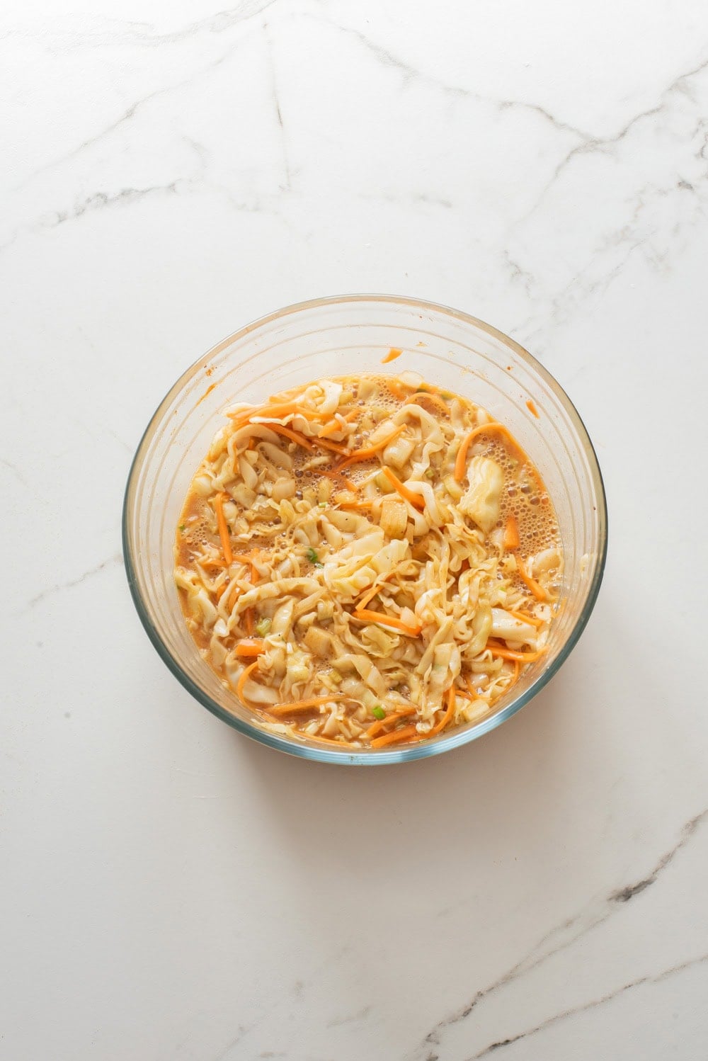 Shredded cabbage, carrots, onions, and eggs mixed together in a bowl for Korean egg sandwich.