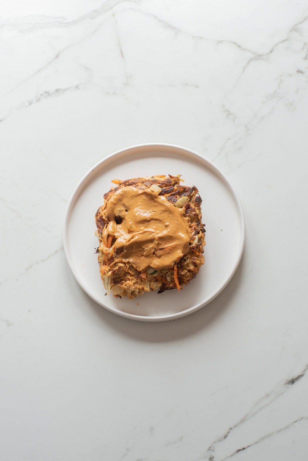 Vegetable egg omelet topped with spicy gochujang mayo during Korean egg sandwich assembly.
