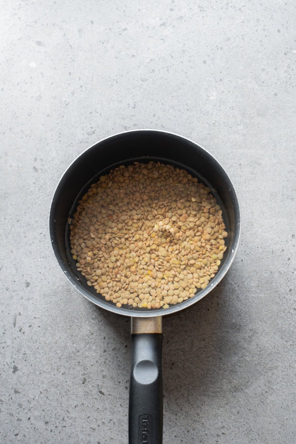 Green lentils simmering in water for Egyptian koshari.