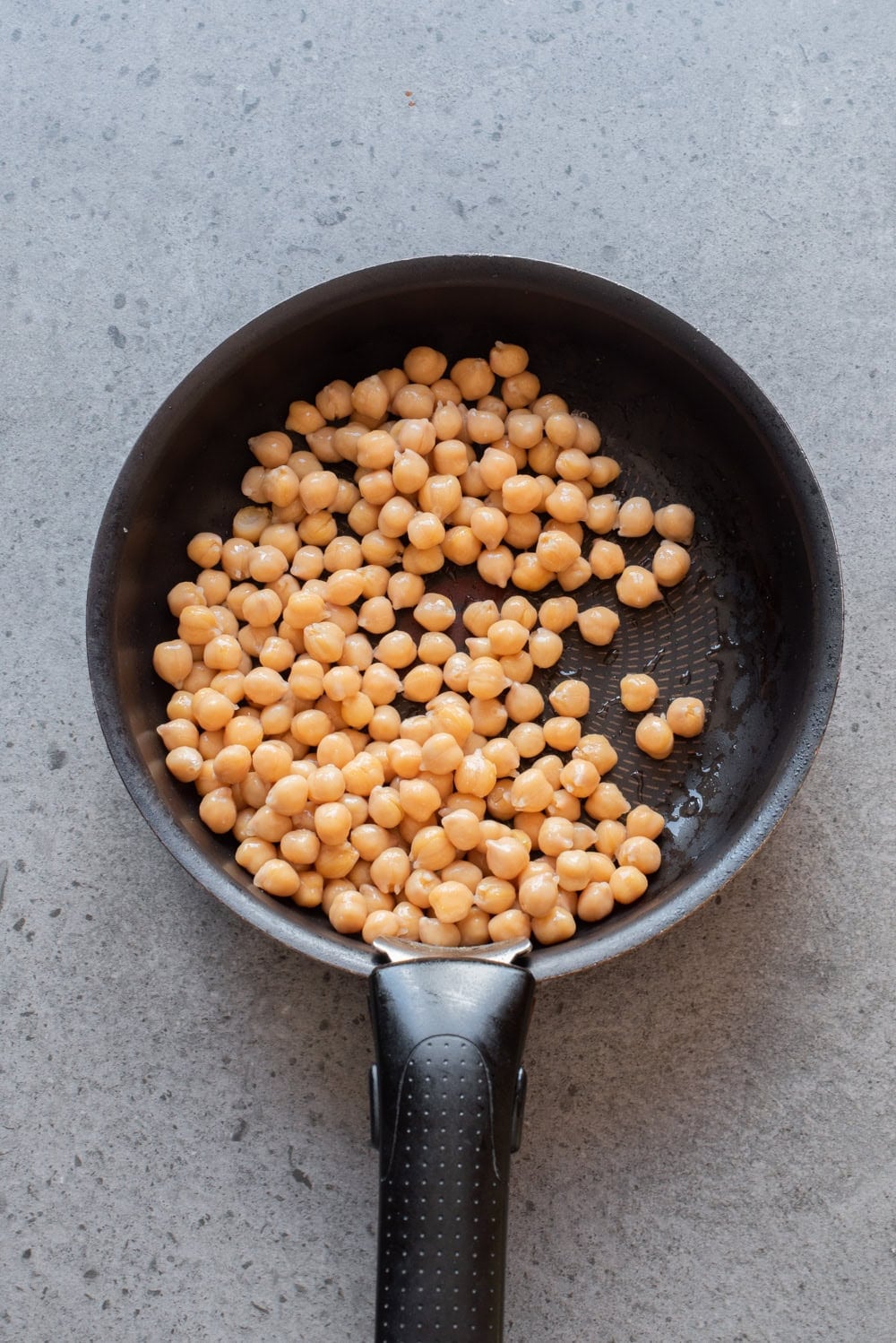 Chickpeas warming in a skillet before serving.