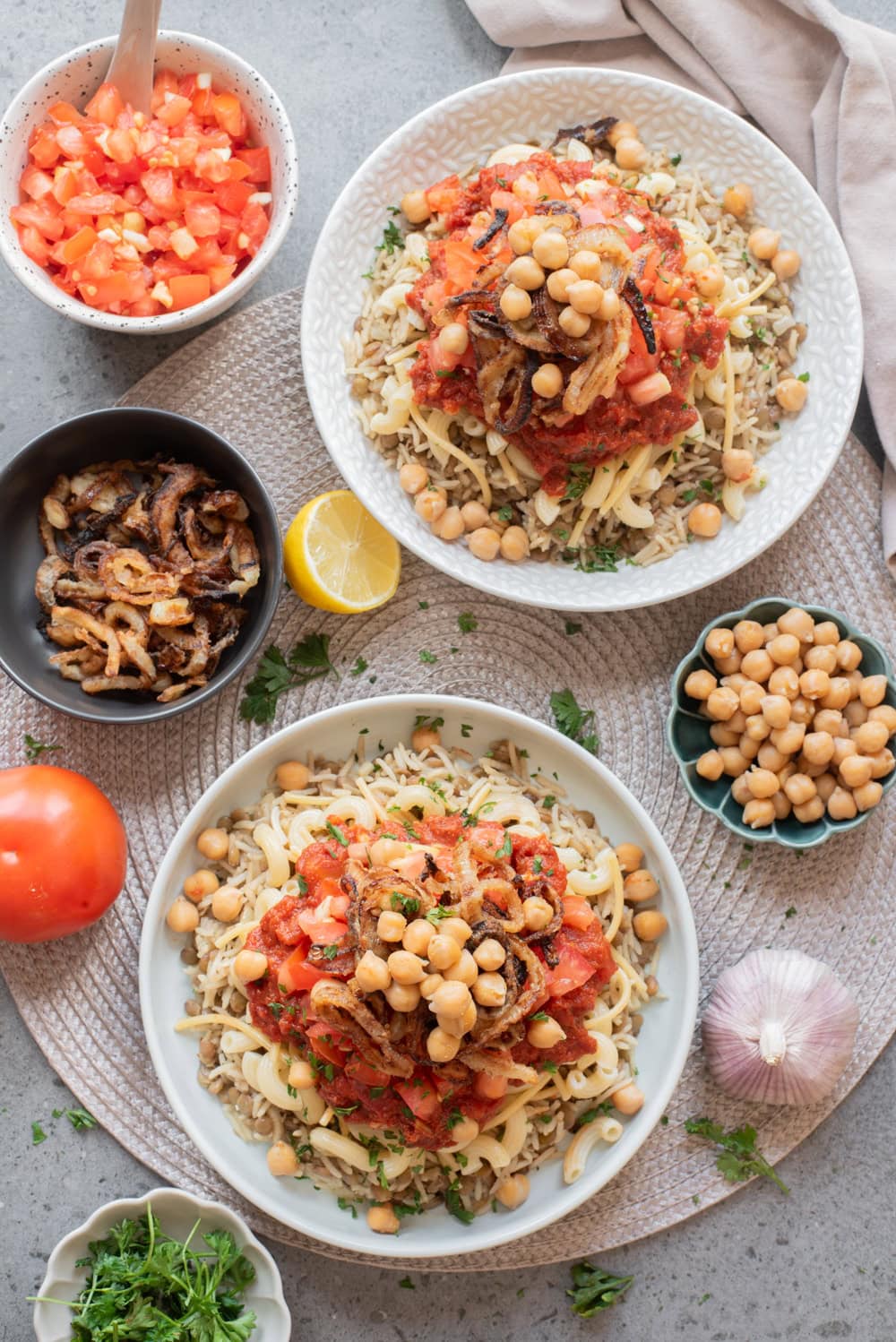 Egyptian koshari assembled with lentil rice, pasta, tomato sauces, chickpeas, and crispy onions.