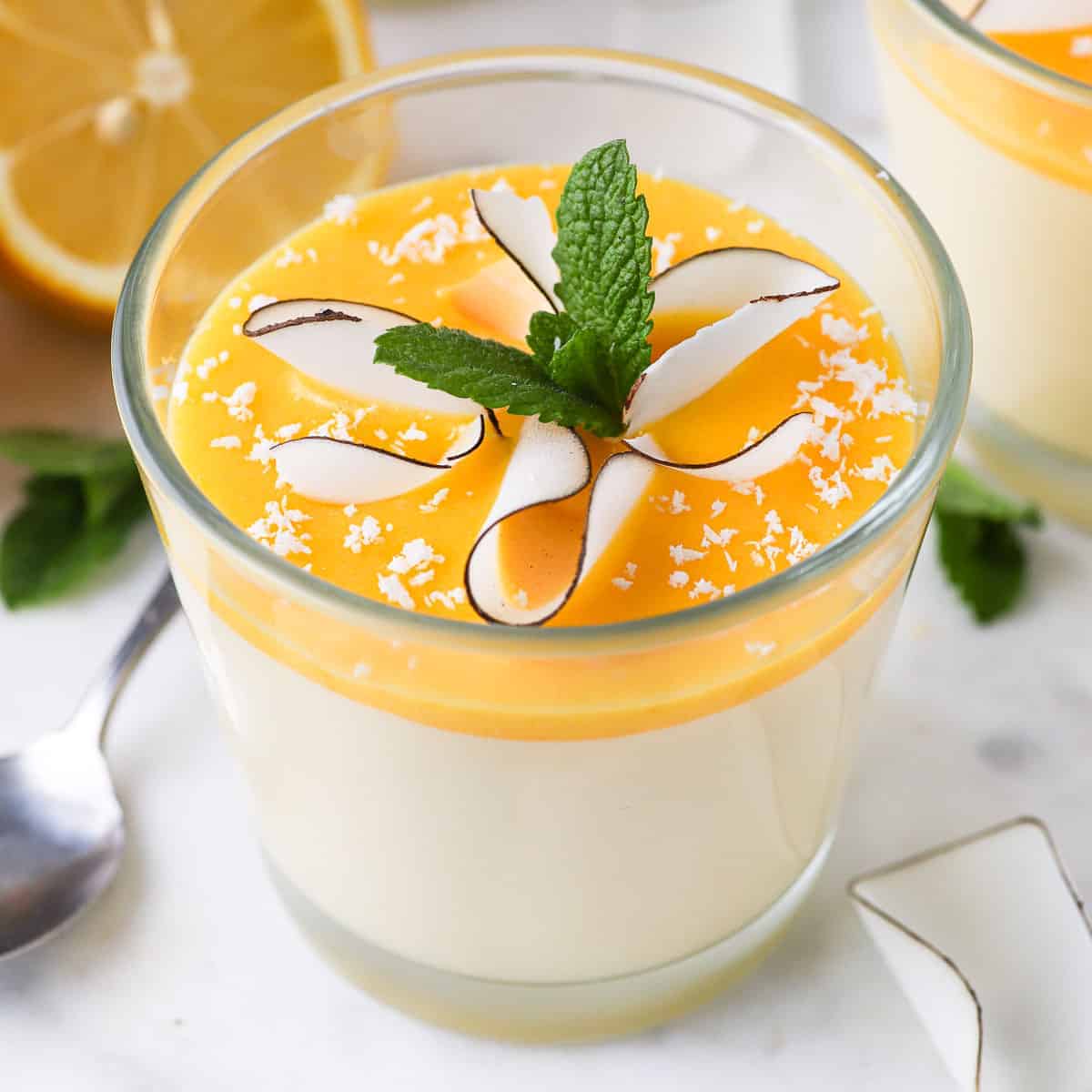 A close-up view of lemon mousse with lemon curd in a cup of glass.