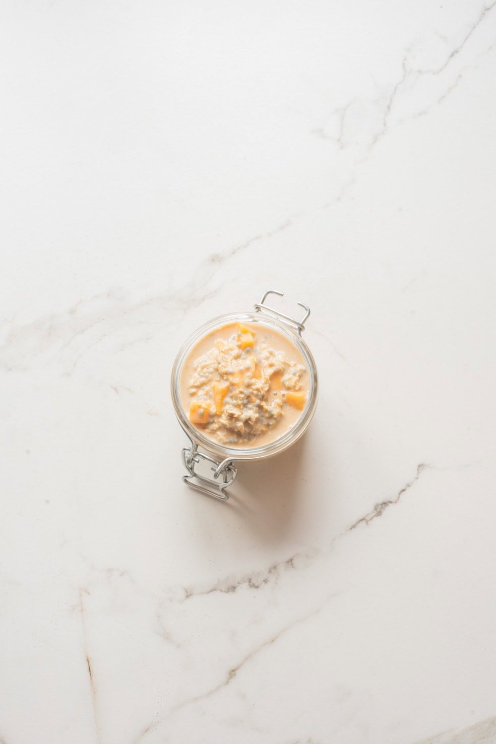 Mango coconut chia overnight oats without toppings in a jar.