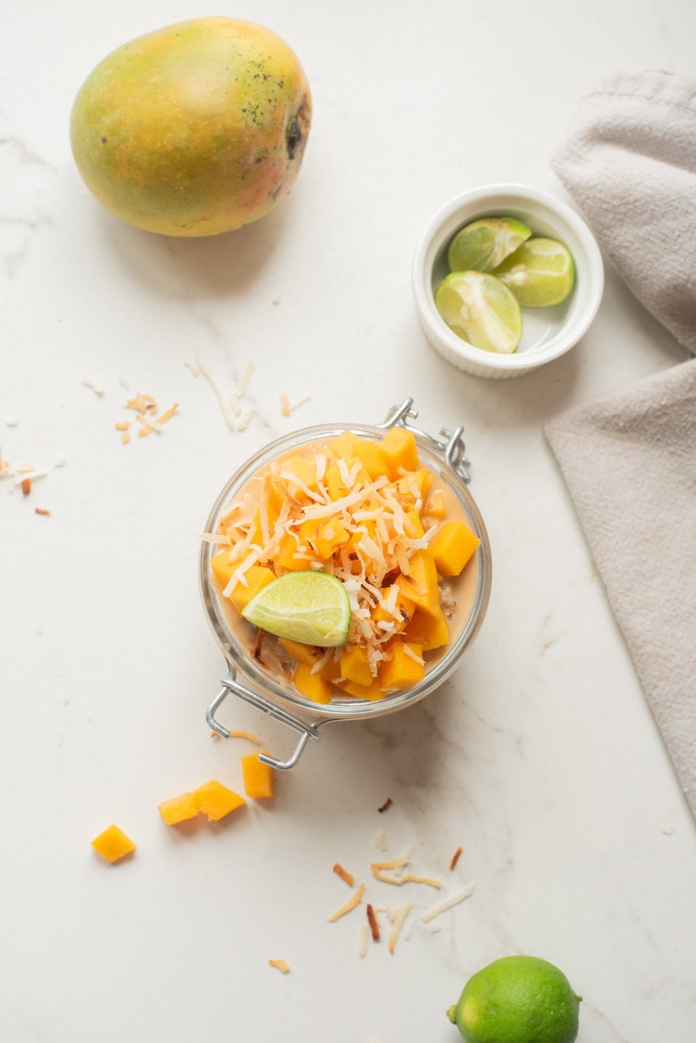 Mango coconut chia overnight oats with toppings in a jar