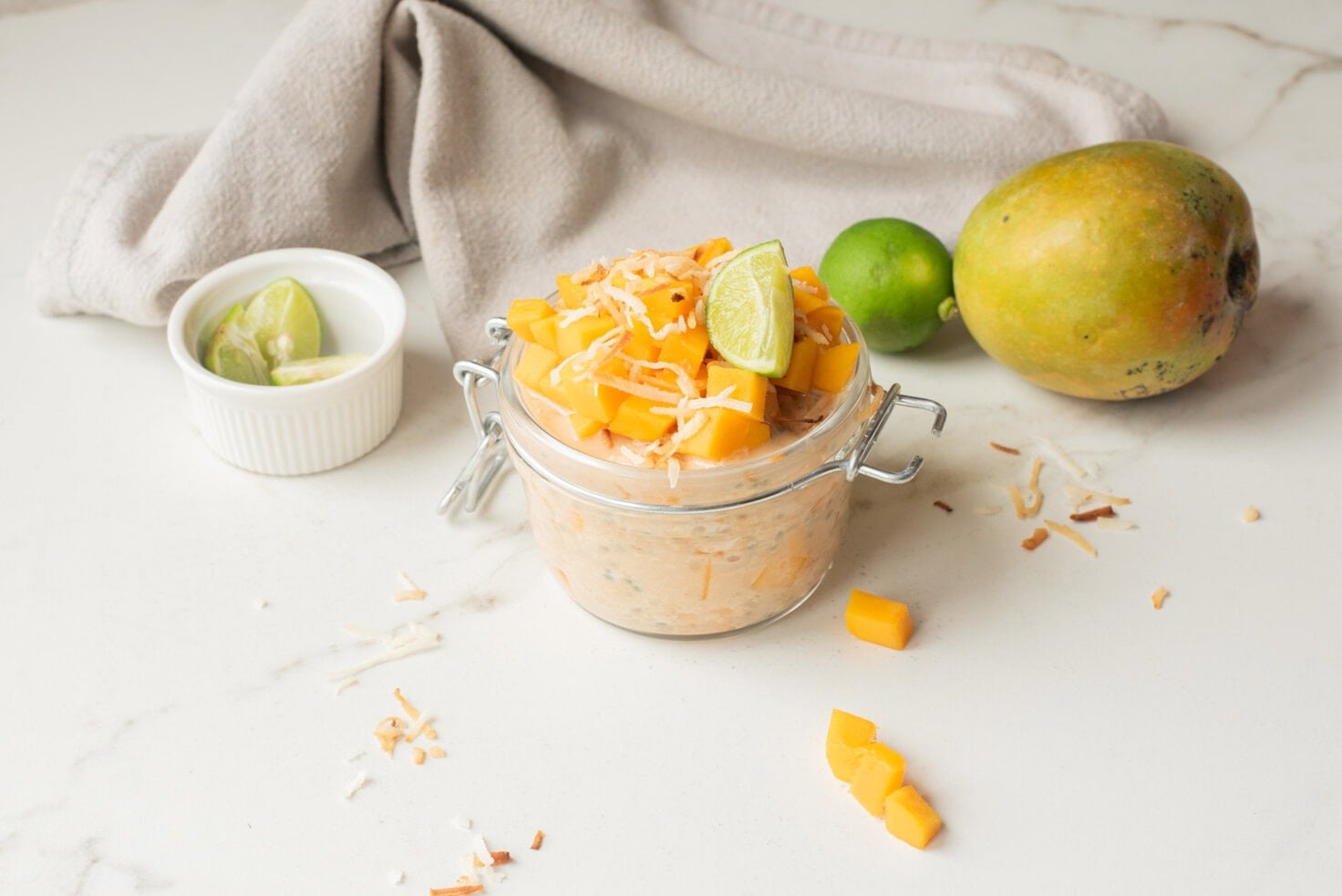 Mango coconut chia overnight oats with toppings in a jar.