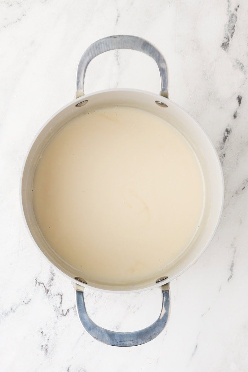 Coconut cream mixture heating in a saucepan to make sweet sauce.