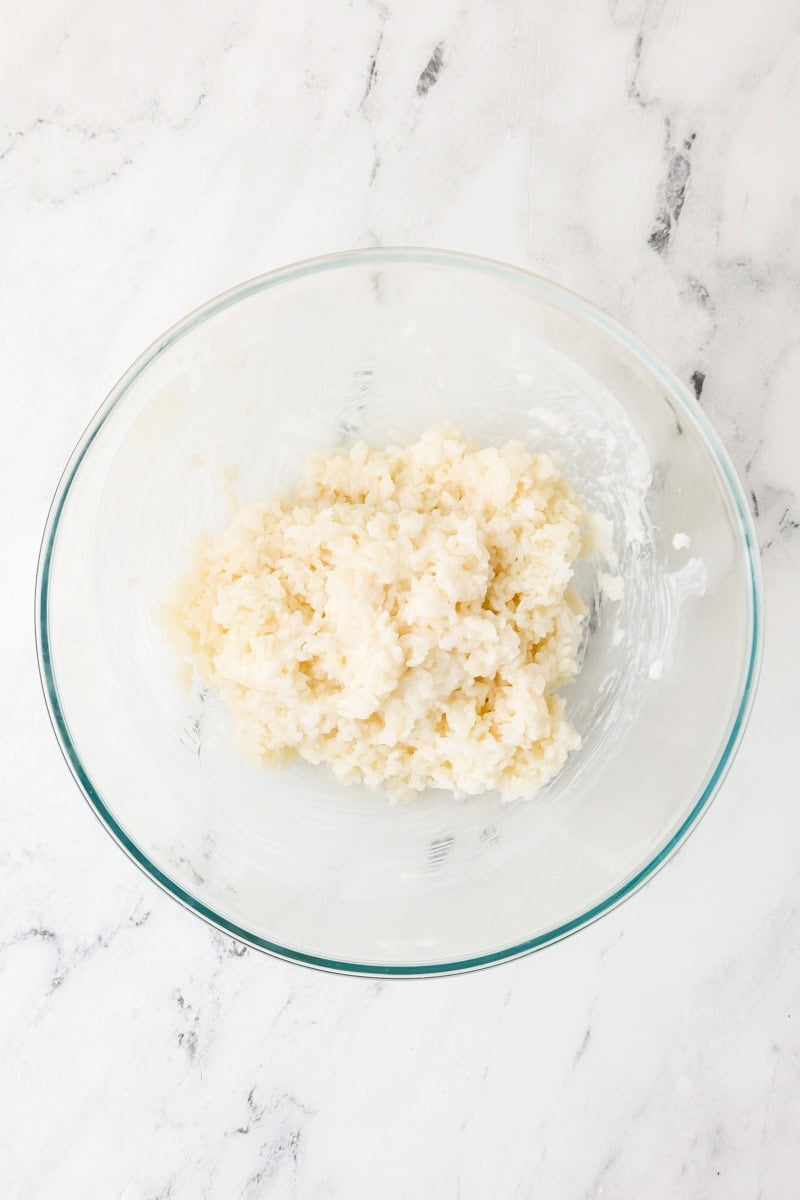 Cooked sticky rice in a bowl with coconut cream sauce.