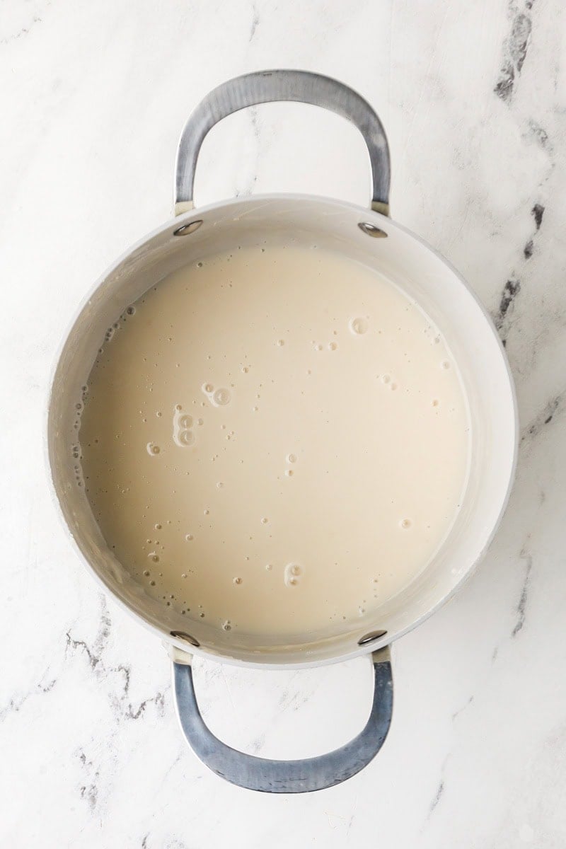 Sweet coconut sauce simmering in a pot for mango sticky rice.
