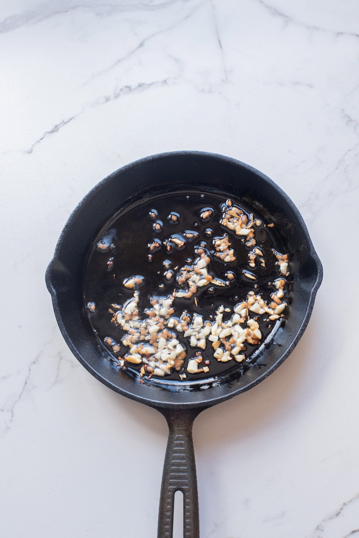 An overhead image of sauteing garlic and ginger.